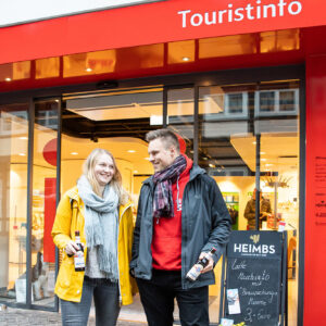 Touristen kaufen Souvenirs in der Tourist-Information Braunschweig während der Mumme-Meile