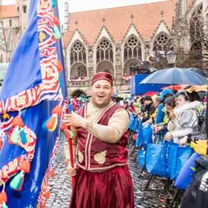 Karneval Braunschweig – Teilnehmerin mit Fahne beim Umzug