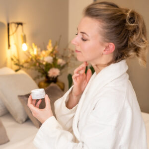 Frau trägt Creme im Badezimmer auf – Beauty- und Wellnessfotografie