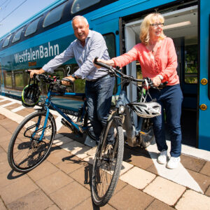 Paar mit Fahrrädern steigt aus einem Zug – Mobilitätsfotografie für ÖPNV