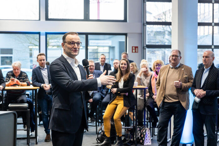 Politiker spricht bei einem Bürgerdialog vor interessierten Gästen im Autohaus