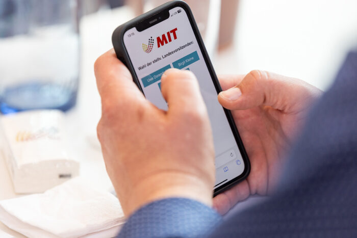 Wahlkampfbild der MIT auf einem Smartphone bei einer Veranstaltung