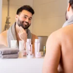 Mann trägt Creme im Badezimmer auf – Beauty- und Wellnessfotografie